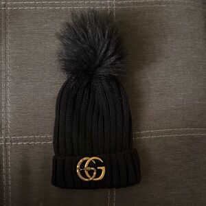 Upcycled GG Brooch on a Black Knit Pom-Pom Beanie